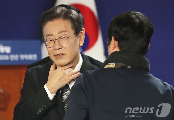 이재명 더불어민주당 대표가 31일 오전 서울 여의도 국회 사랑재에서 열린 2024 신년 기자회견에서 취재진과 이야기를 나누며 목을 만지고 있다.